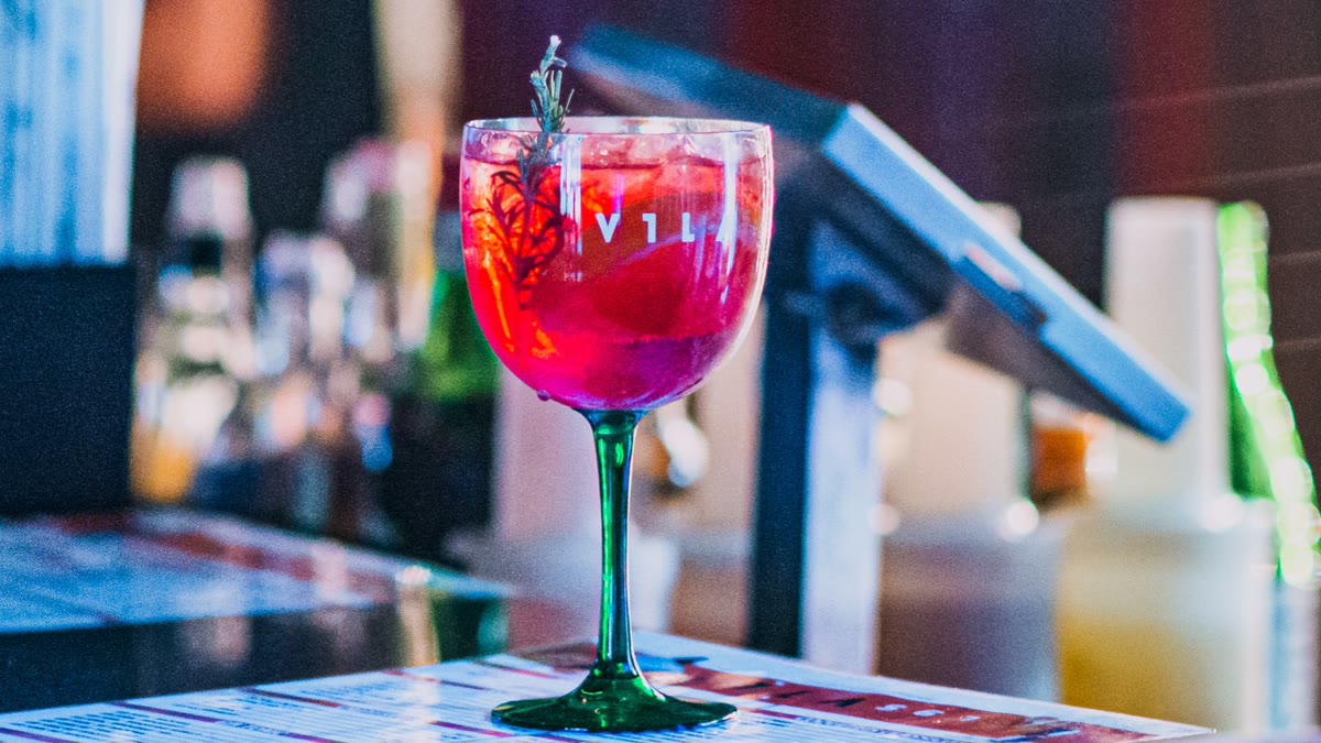 Drink da casa na taça do Vila, servido no balcão do bar