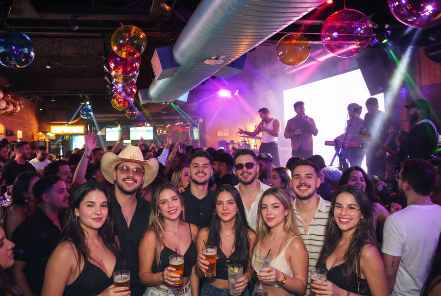 Turma de amigos na pista com o show ao vivo no palco atrás