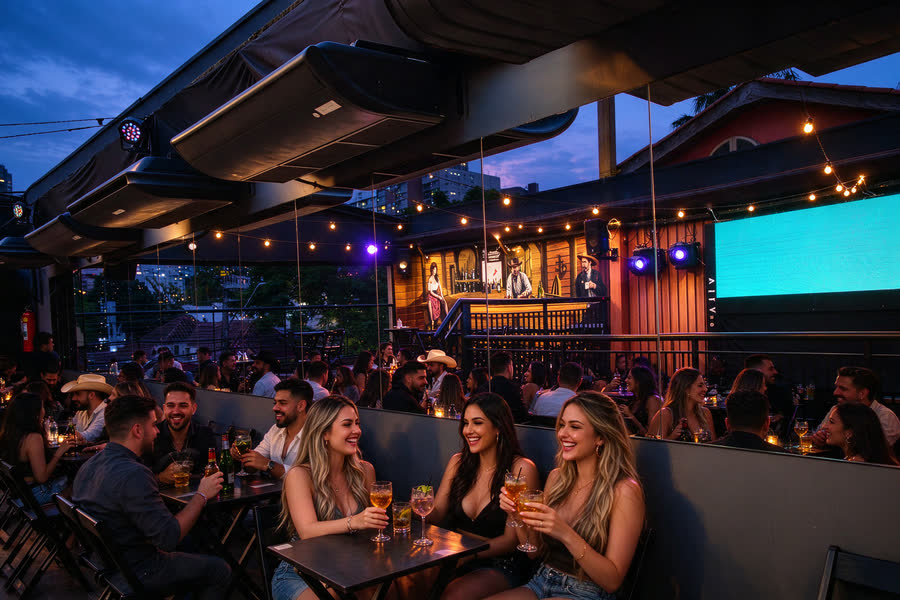 Amigas brindando no rooftop na hora azul, com o painel LED aceso